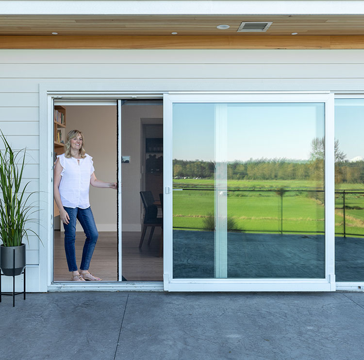 Système de porte vitrée coulissante moderne avec moustiquaire rétractable, ouvrant sur un patio avec vue sur le terrain de golf