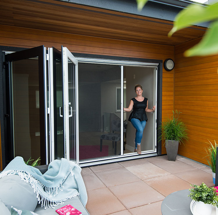 Patio contemporain avec portes vitrées bi-pliantes, plafond en planches de cèdre et moustiquaires rétractables menant à la salle à manger extérieure