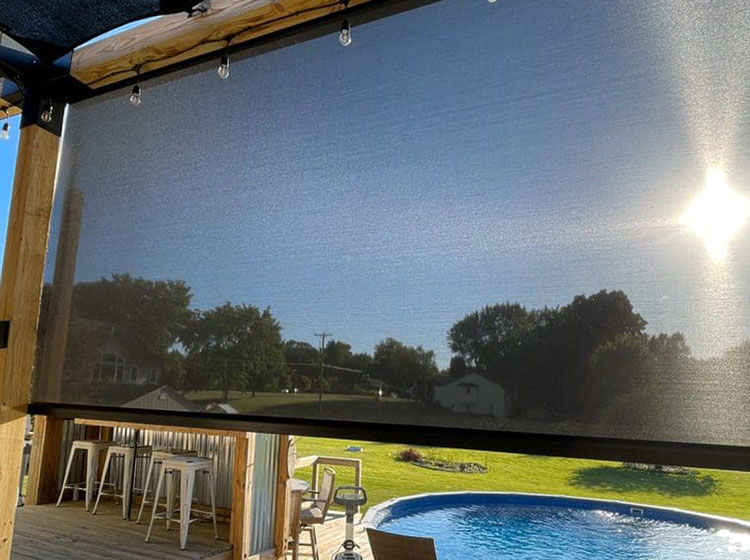 Store solaire extérieur avec système de guide-câble monté sur une grande fenêtre, avec sièges de bar et vue sur la piscine
