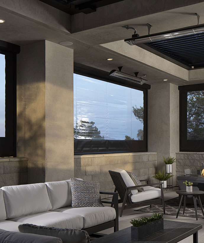 Espace intérieur-extérieur de luxe avec écrans rétractables offrant des vues panoramiques et des sièges de salon modernes
