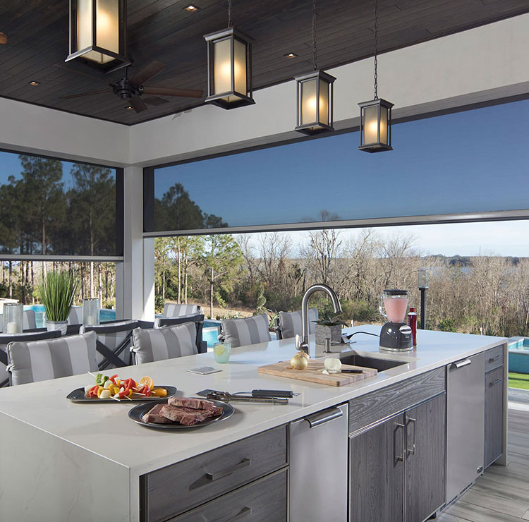 Cuisine extérieure de luxe avec moustiquaires rétractables, surplombant la piscine et une vue panoramique sur l'eau