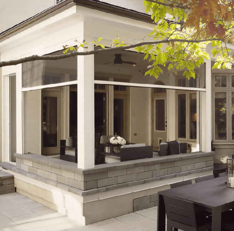 Terrasse moderne blanche avec base en pierre et moustiquaires motorisées, avec salle à manger extérieure et grill intégré
